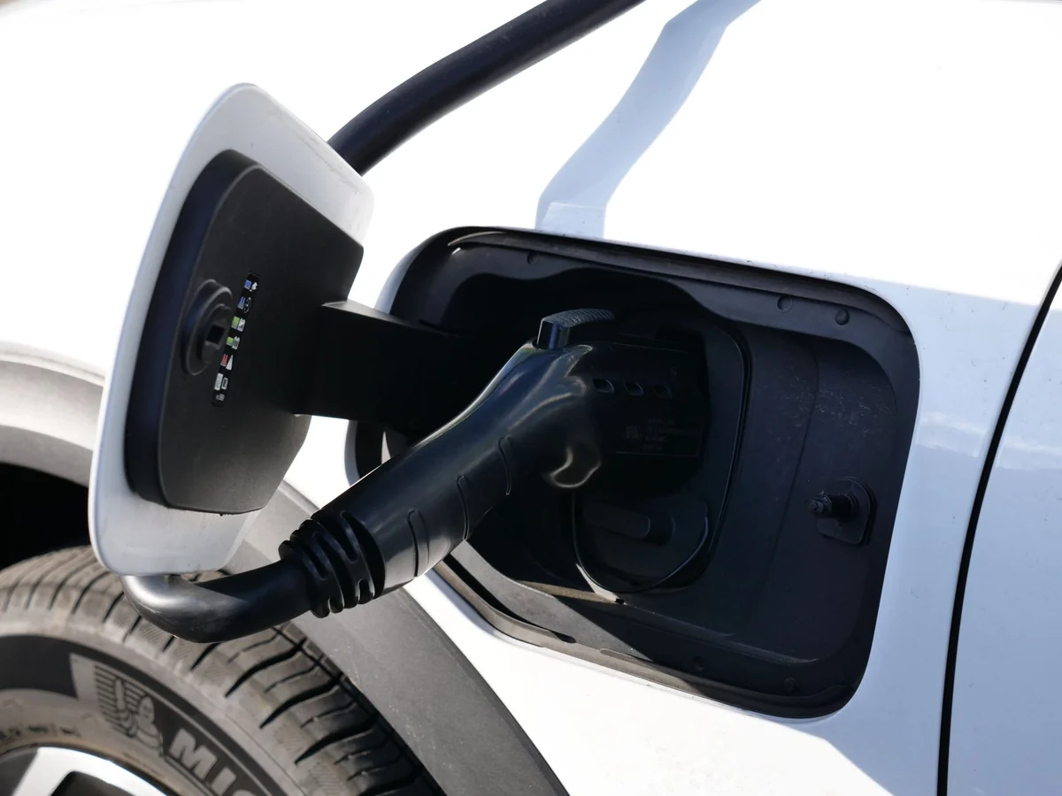 Electric vehicle charging cable plug with USB port and charging port.