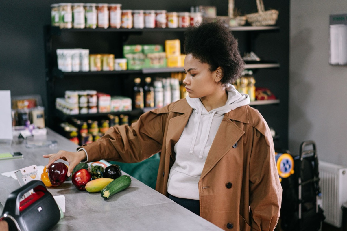 persona comprando alimentos baratos con lista de compras