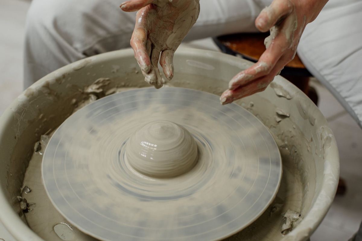 Artisan façonnant de la poterie à la main.