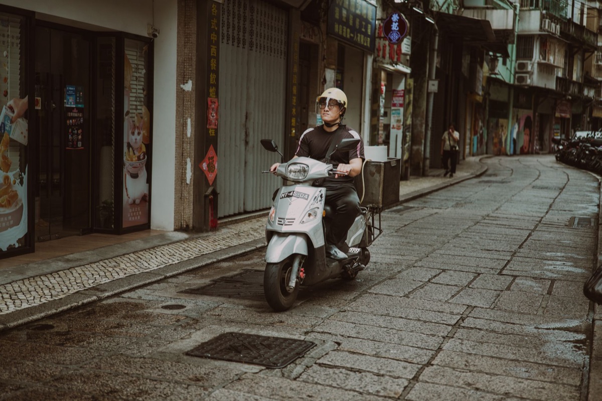 Een scooterhelm en stuur van een bezorgscooter.