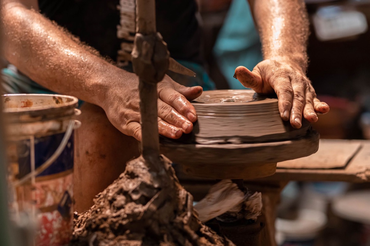 Mãos artesãs trabalhando em cerâmica para venda.