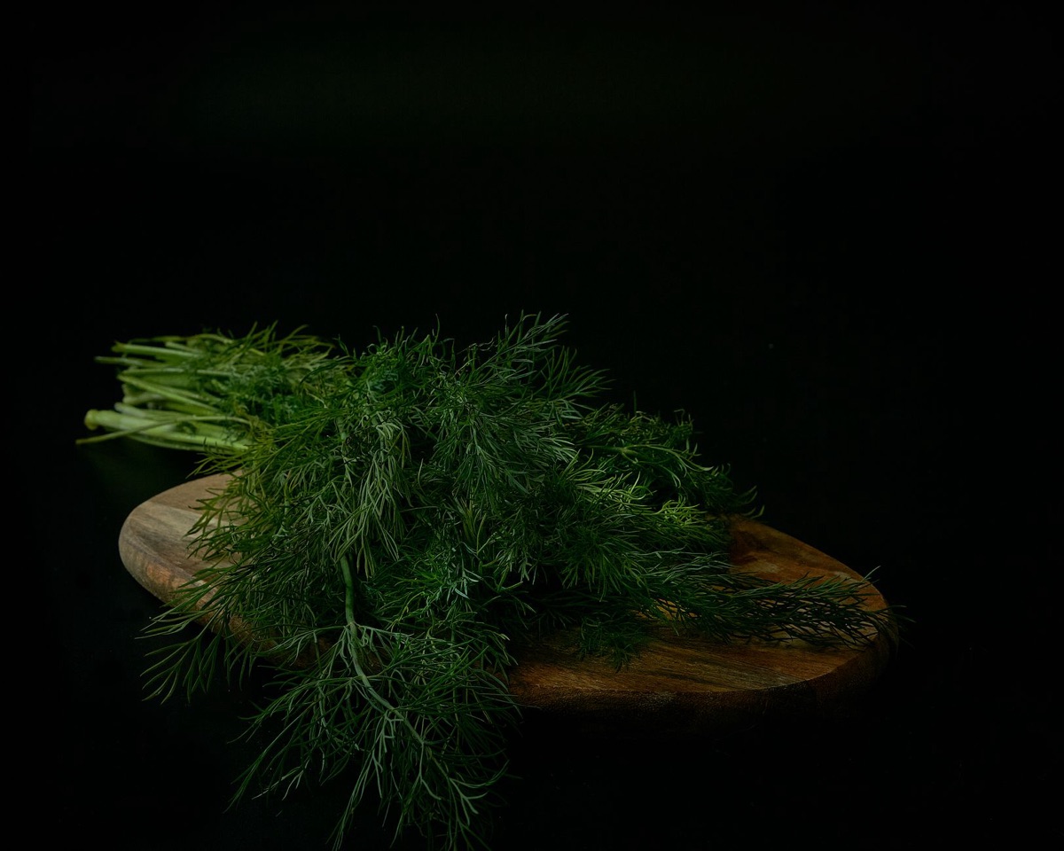 A vibrant pile of chopped fresh herbs on a wooden cutting board, suggesting ingredient preparation