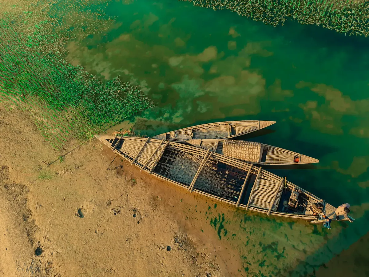 Stunning aerial shot of wooden boats on a clear lake in Kurigram, Bangladesh.
